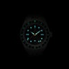 Lorier Hyperion GMT automatic watch in darkness showing Superluminova lume on hour markers, handset, and GMT bezel numerals glowing blue-green against black background.