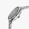 A close-up side profile of the Lorier Neptune diver's watch. It has a stainless steel case and three-link bracelet, a black dial, and a prominent ridged crown, shown against a light gray background.