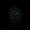 Lorier Neptune automatic dive watch in darkness showing Superluminova lume on hour markers, handset, and dive bezel numerals glowing blue-green against black background.
